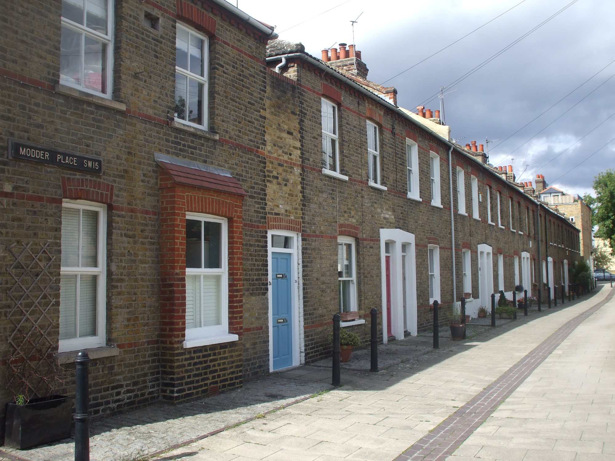 A row of Victorian terraced cottages on Modder Place in Putney, with front doors opening onto the pavement