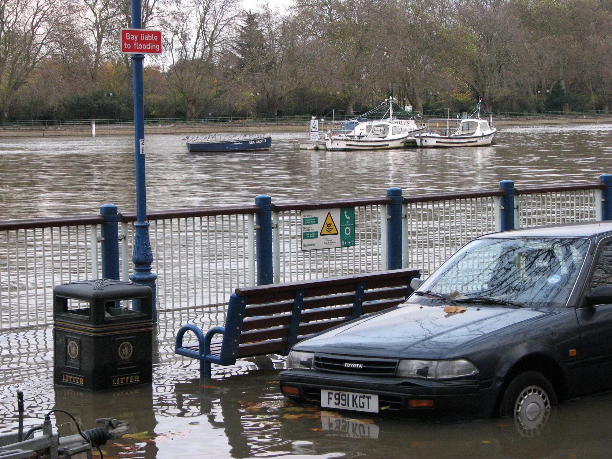 Tide over the parking bays on Putney Embankment beside a sign warning the bay is liable to flooding